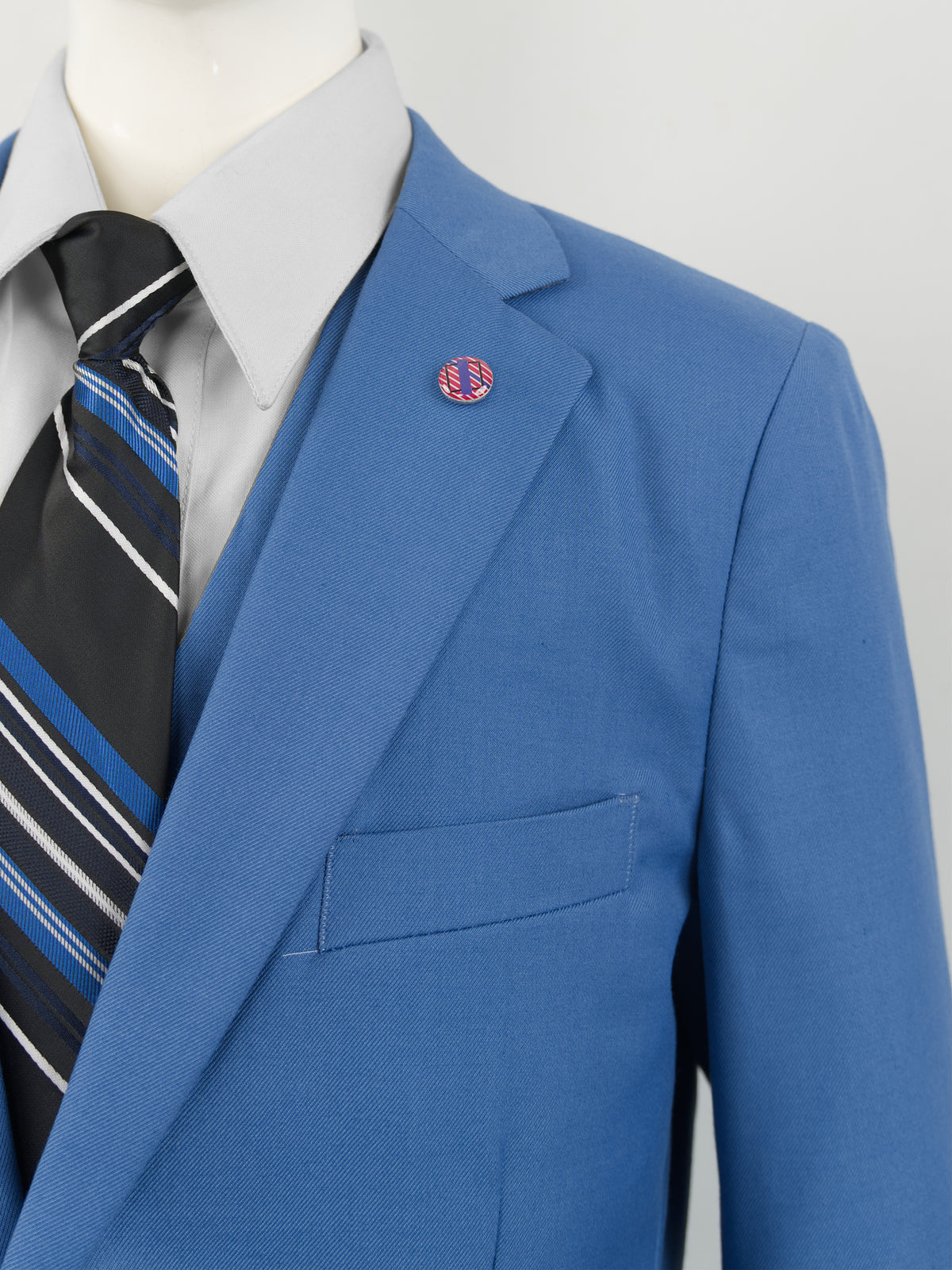 Detalle de la solapa del Traje juvenil Dalí índigo con su broche rosa